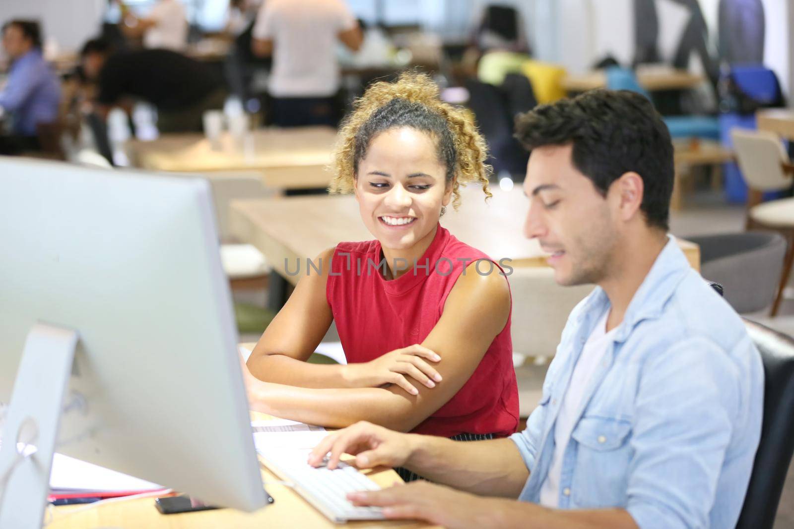 Business people working in office on desktop computer, Group of happy business people in smart casual wear looking at the laptop and gesturing. Achieving success.