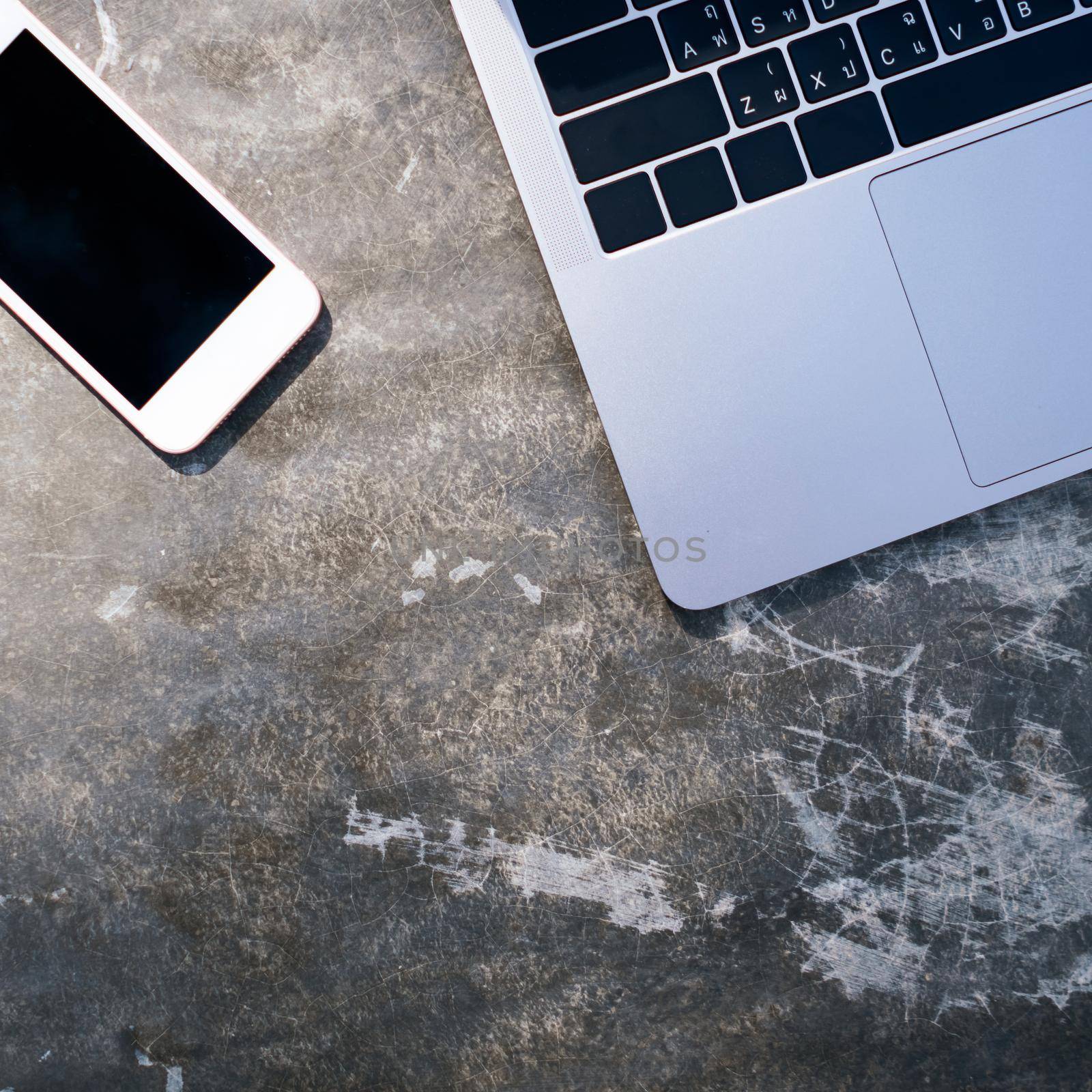 Top view of modern laptop or notebook with phone to work. Office desktop on table background.