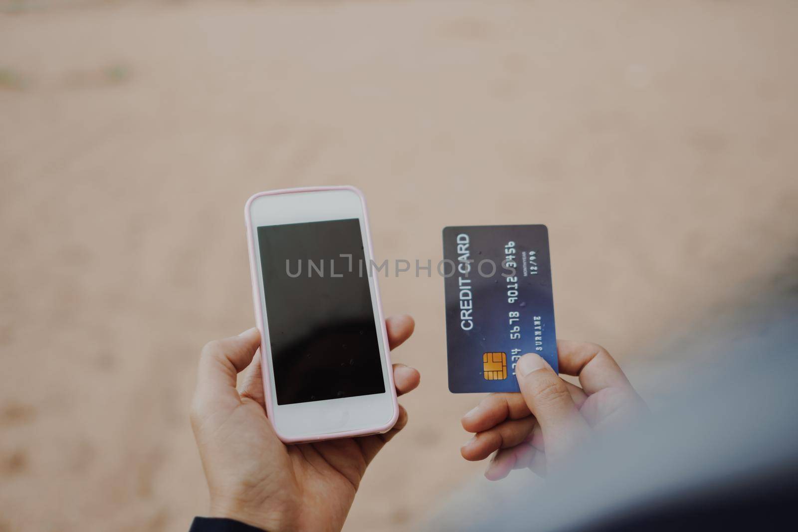 Woman hands holding credit card and using mobile smartphone for online shopping or reporting lost card, fraudulent transaction.New normal generation gadget.