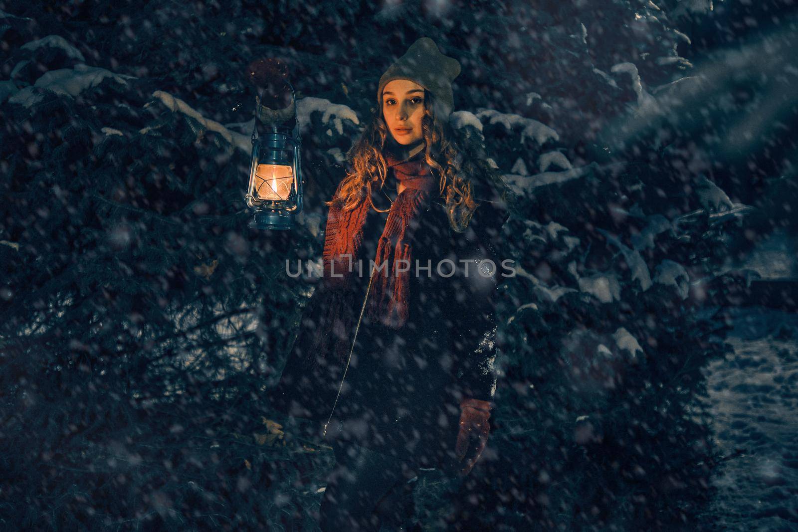 Young girl with lantern in winter forest fairy tale, book cover