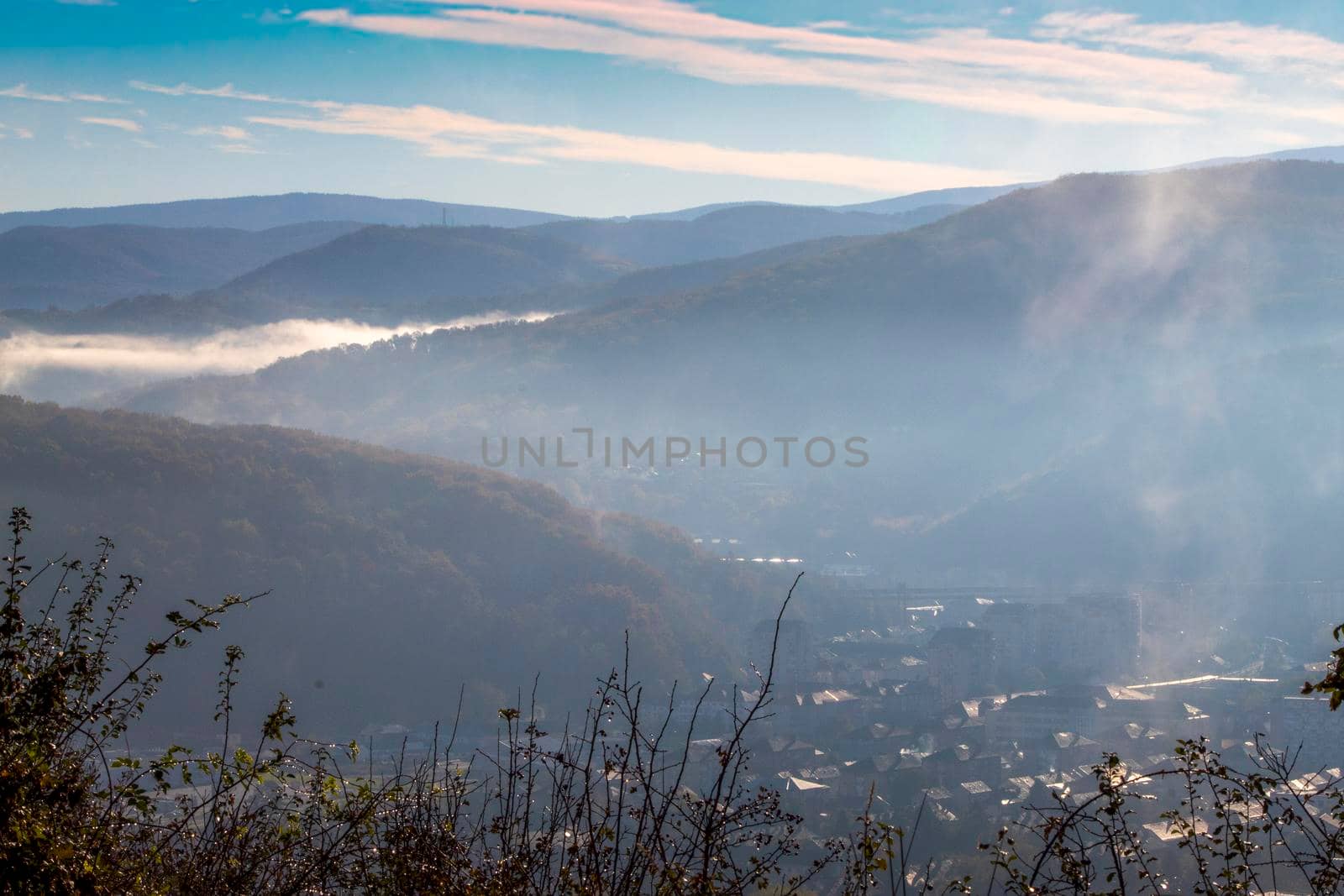 City ​​seen from above, covered by the morning fog with the blue sky by bybyphotography