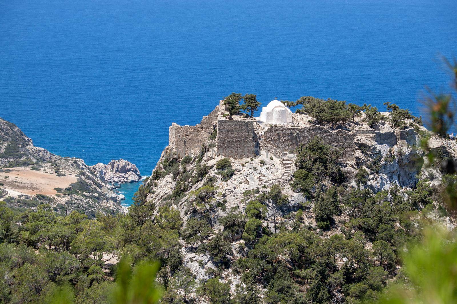 Scenic view at landscape and coastline near Monolithos on Greek island Rhodes with the aegaen sea in the background and old ruins with church on a hill by reinerc