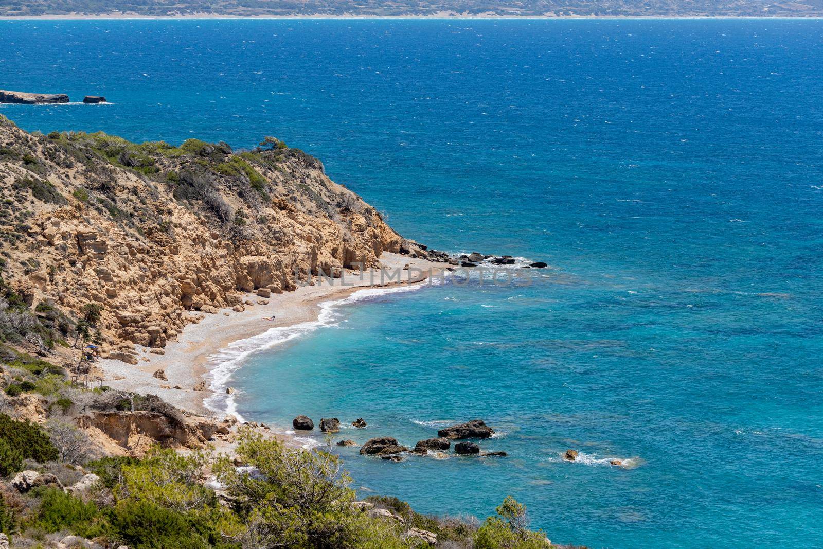 Panoramic view at beach Akra Fourni nearby Monolithos  at Rhodes island with green vegetation in the foreground and the aegean sea in the background