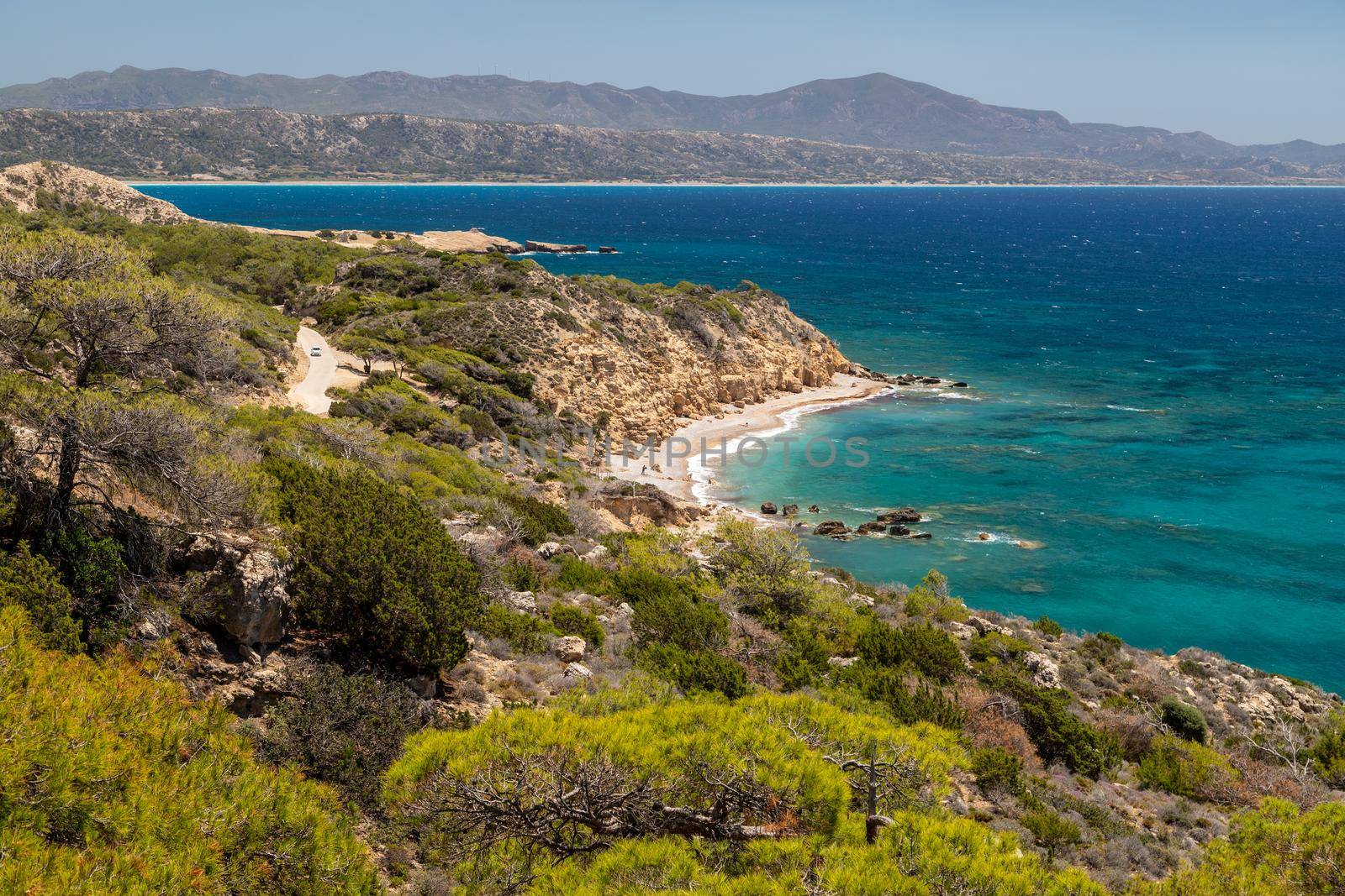 Panoramic view at beach Akra Fourni nearby Monolithos  at Rhodes island with green vegetation in the foreground and the aegean sea in the background