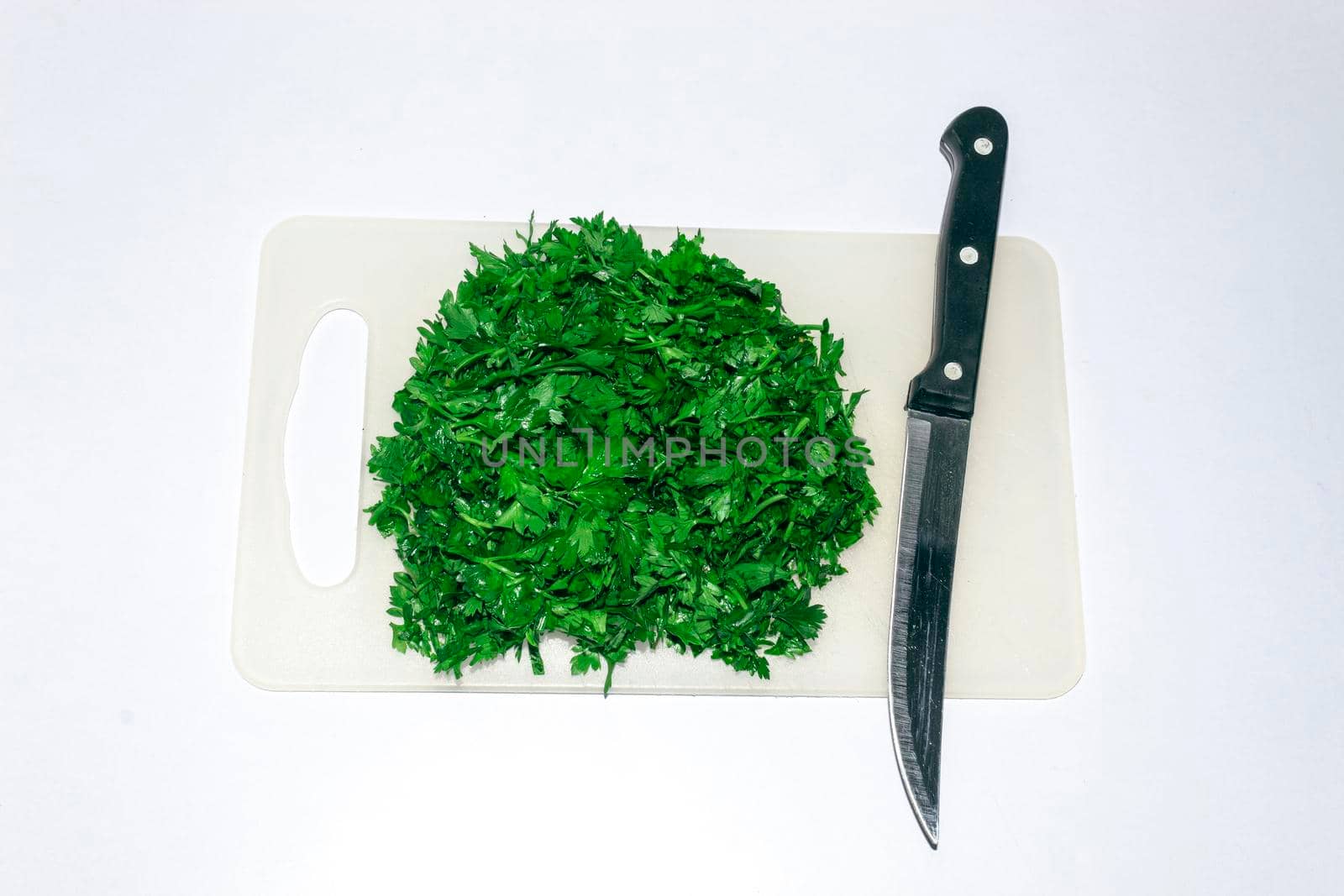 Finely chopped parsley on a chopping board by bybyphotography