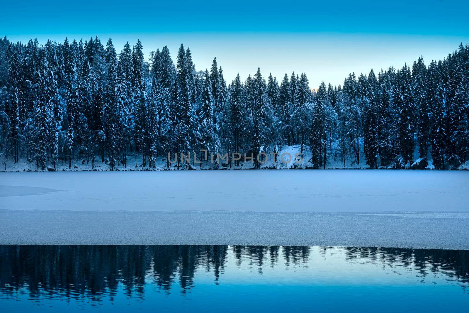 the panorama of the lake of Fusine, Tarvisio, frozen in winter