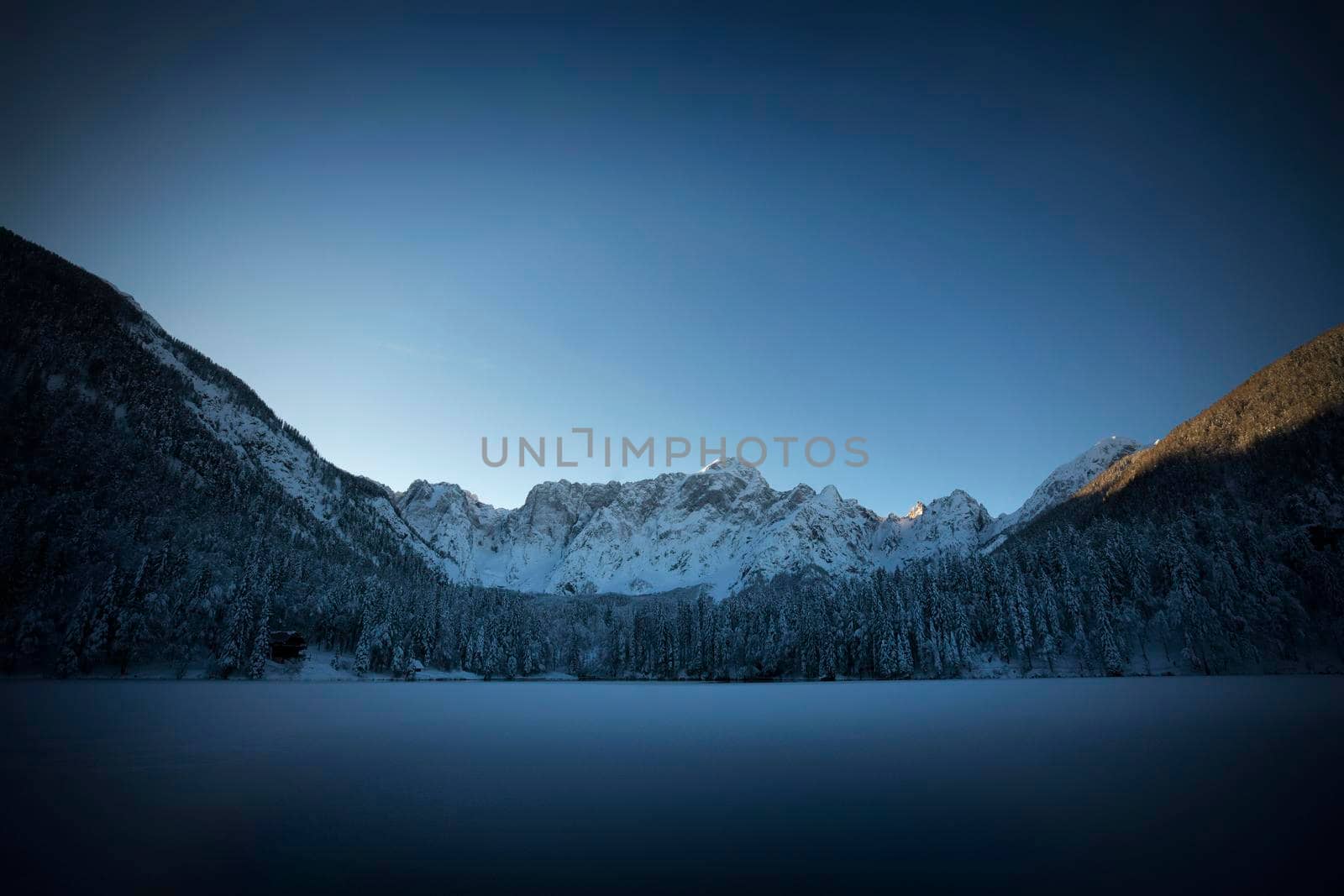 the panorama of the lake of Fusine, Tarvisio, frozen in winter