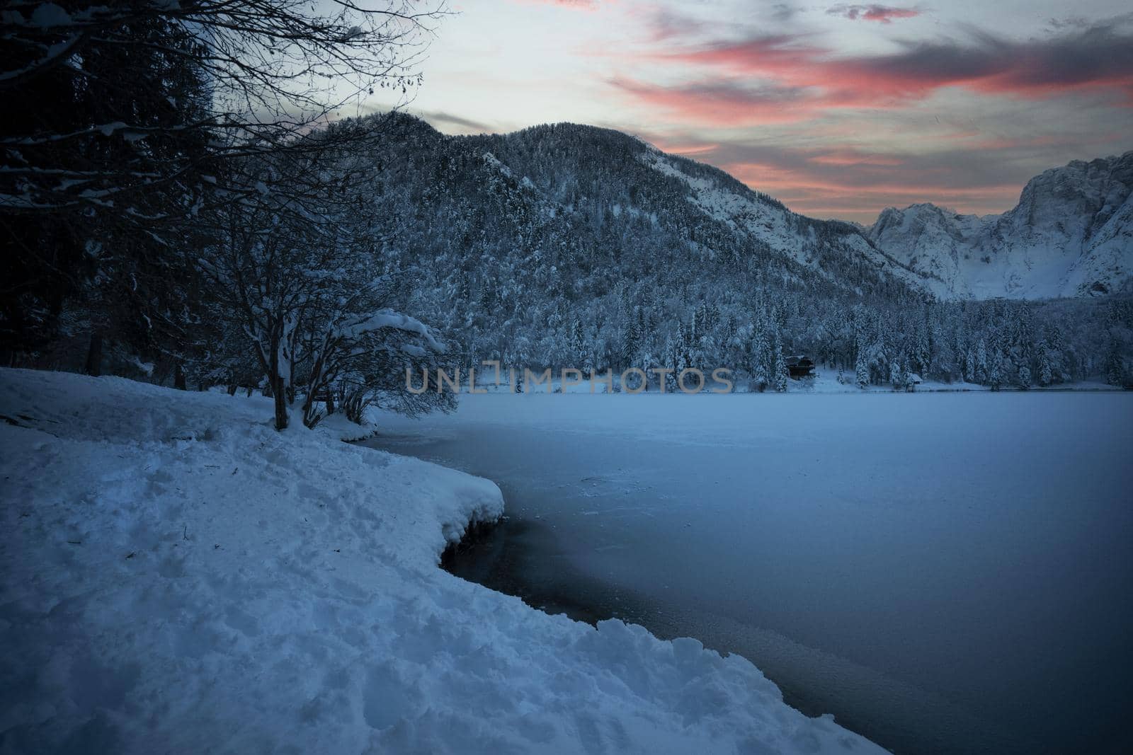 the panorama of the lake of Fusine, Tarvisio, frozen in winter