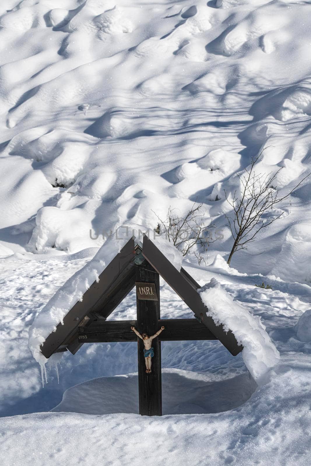 a snow covered crucifix in winter