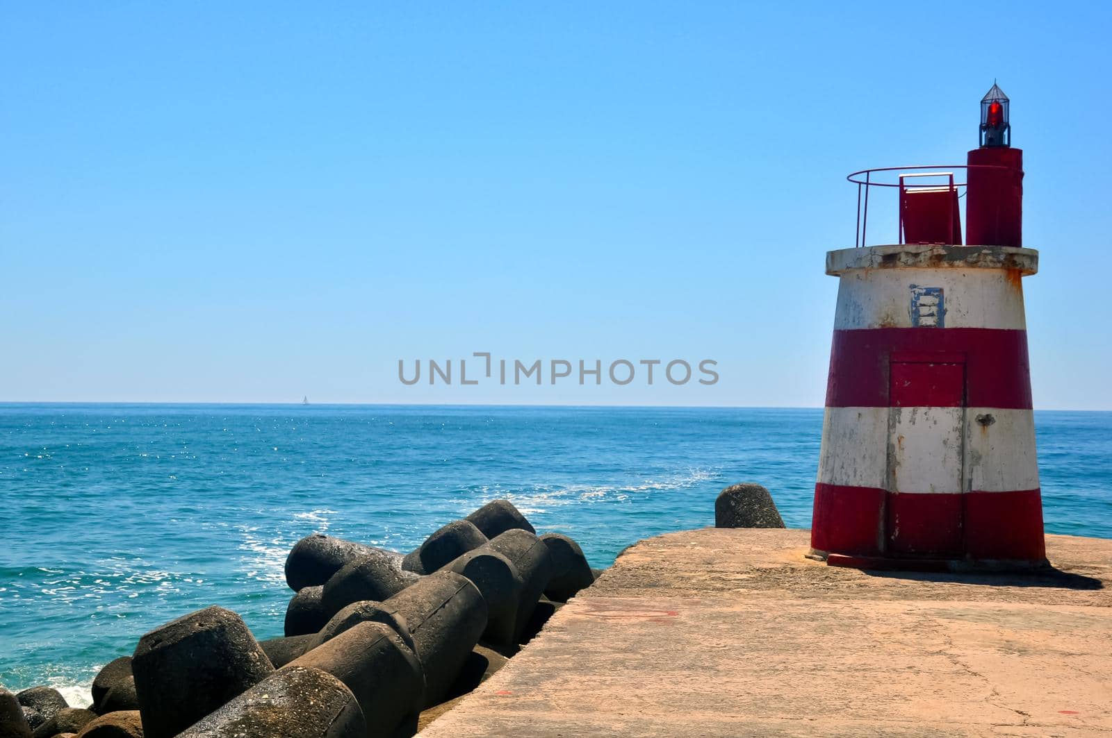 Small lighthouse on the ocean shore by Bezdnatm