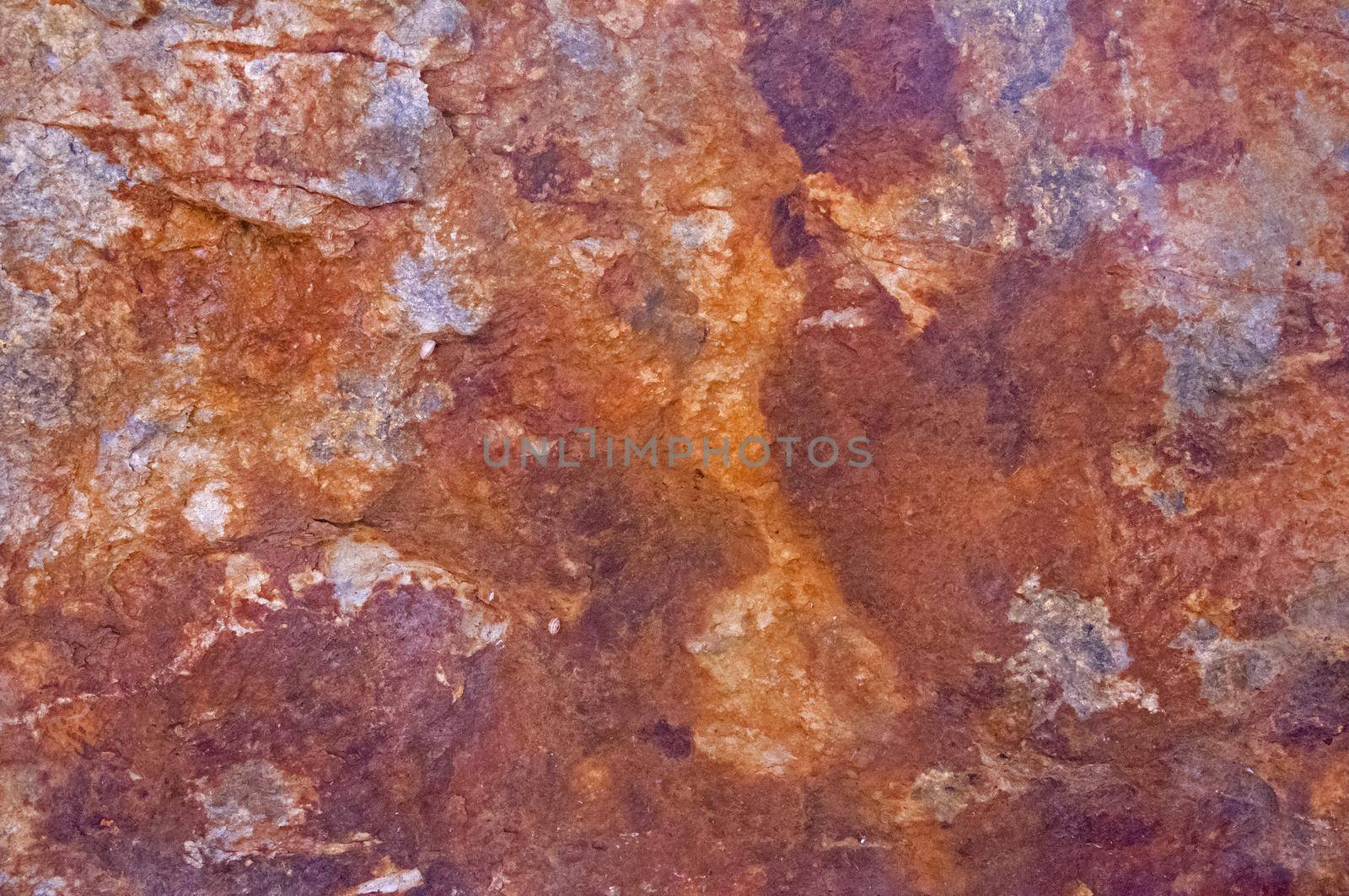 Rusty stone surface with grey, brown, and dark brown spots, Spain