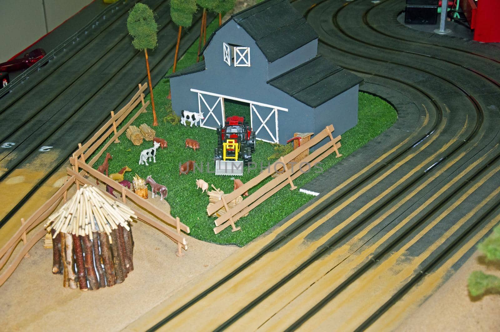 Small grey toy housestock, red tractor and wooden barn, right up view