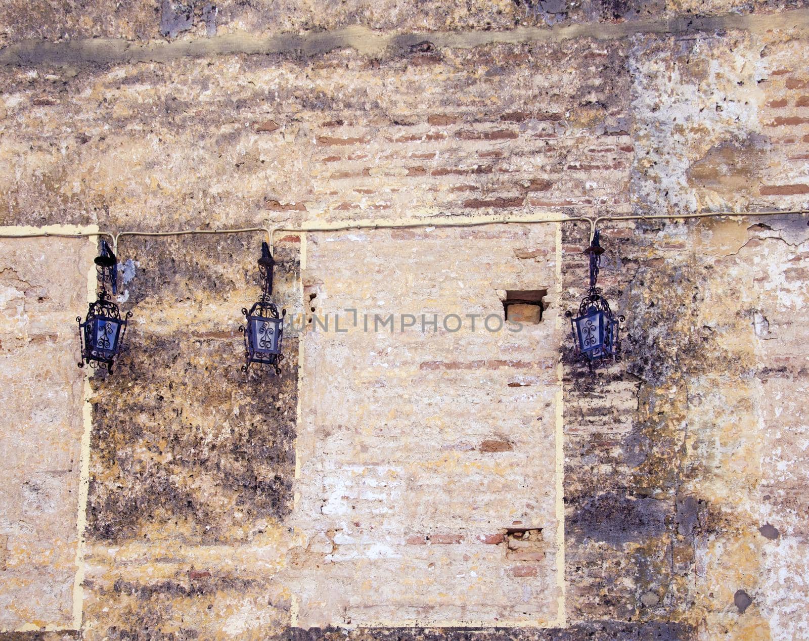 Three black lamps on the stone ancient cathedral wall