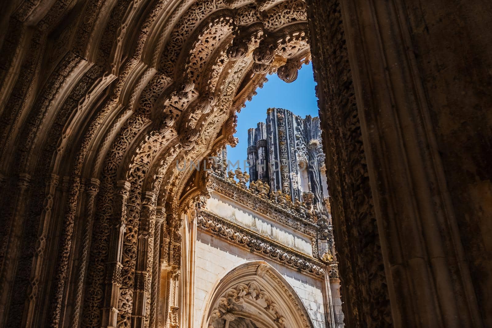 Low angle shot to emphasize the majestic entrance portal to the unfinished chapels of the Monastery of Batalha in Portugal. by Riccarduska