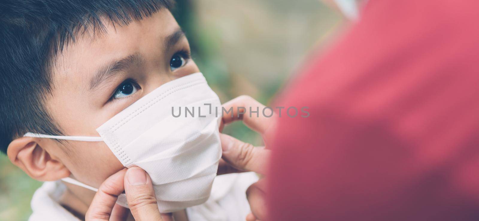 Mother take care son with face mask for protection disease flu or covid-19 outdoors, mom wearing on medical mask with child safety for protect outbreak of pandemic, medical concept, banner website.