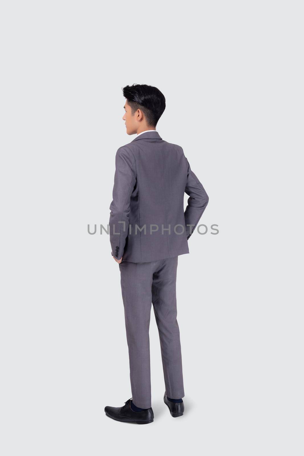Rear view of young asian businessman in suit hand in pocket with confident isolated on white background, back of business man is manager or executive or employee thinking with success, full length. by nnudoo