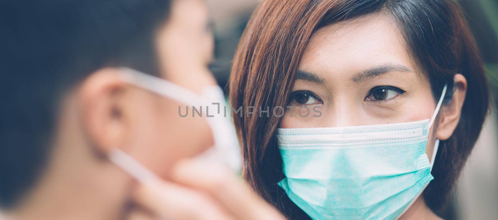 Mother take care son with face mask for protection disease flu or covid-19 outdoors, mom wearing on medical mask with child safety for protect outbreak of pandemic, medical concept, banner website. by nnudoo