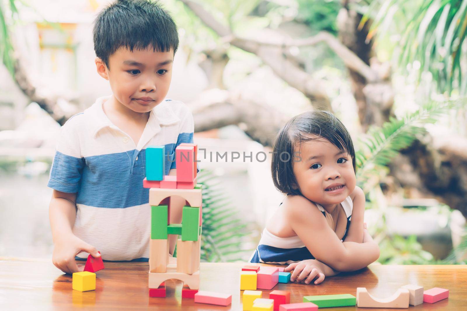 Asian boy and gril playing wooden block toy on table for creative and development with enjoy, happy child learn skill for activity puzzle and creativity for game on desk at home, education concept.