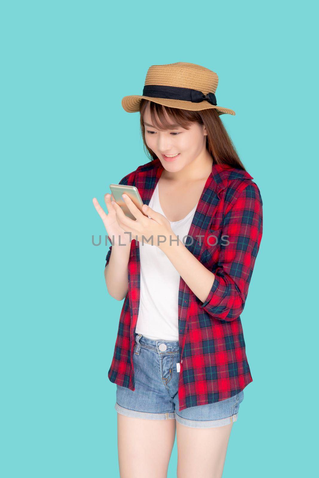 Beautiful young asian woman touch smart mobile phone in vacation isolated on blue background, asia girl talking or chat message on smartphone in travel summer trip, journey or education concept. by nnudoo