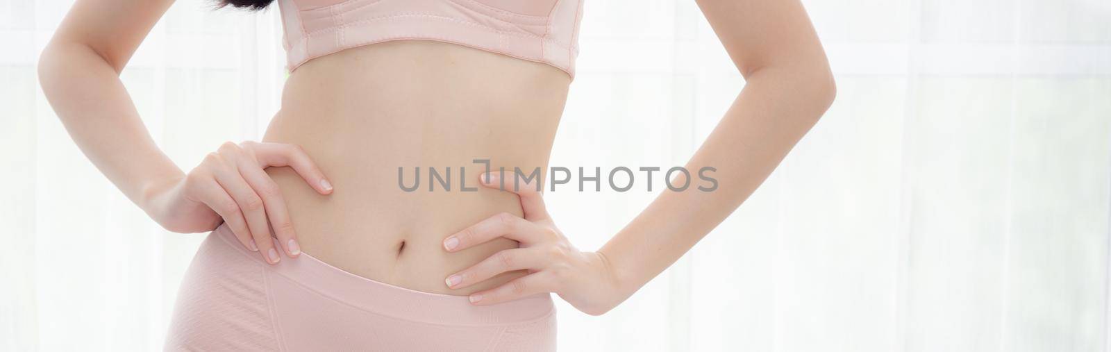 Closeup asian woman wear underwear beautiful body belly slim shape sexy with diet at room, asia girl wear bra hand touch abdomen thin with weight loss, health and wellness concept, banner website.