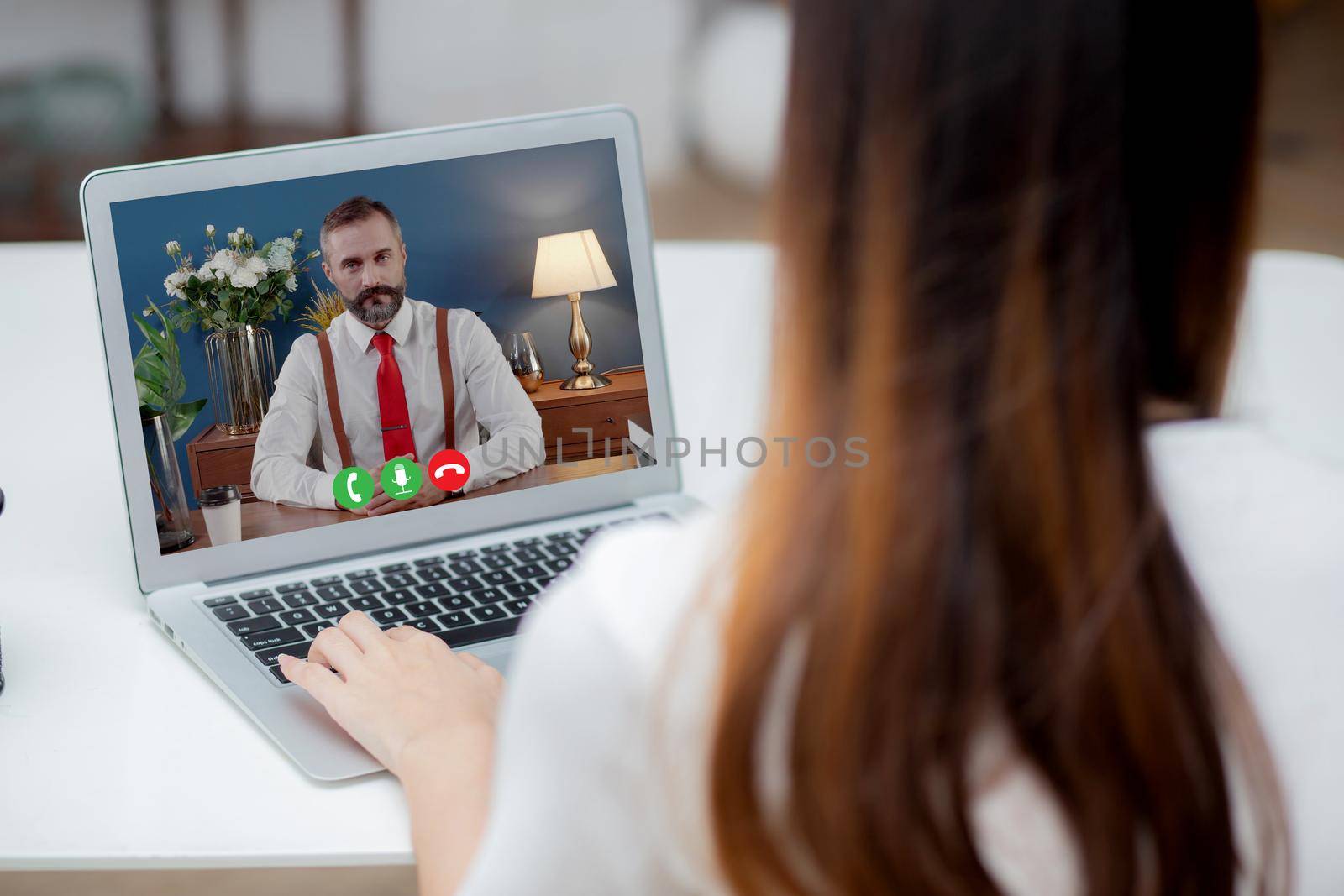 Young asian businesswoman video conference and discussion with businessman, woman work from home with laptop computer with social distancing, meeting online, communication and business concept.