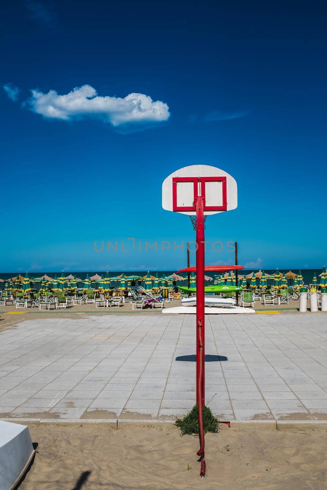 Pescara, Italy: rear view of a basketball hoop by beach. Bright colors in a summer day.