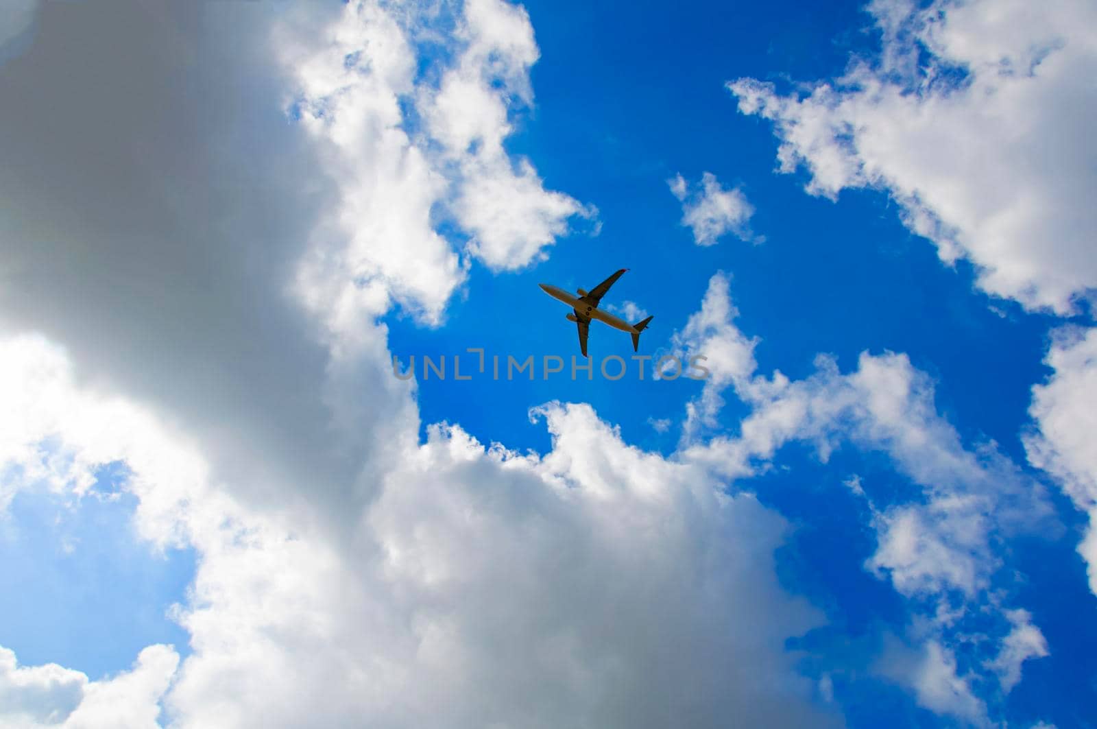 Passenger plane in the blue cloudy sky by Bezdnatm