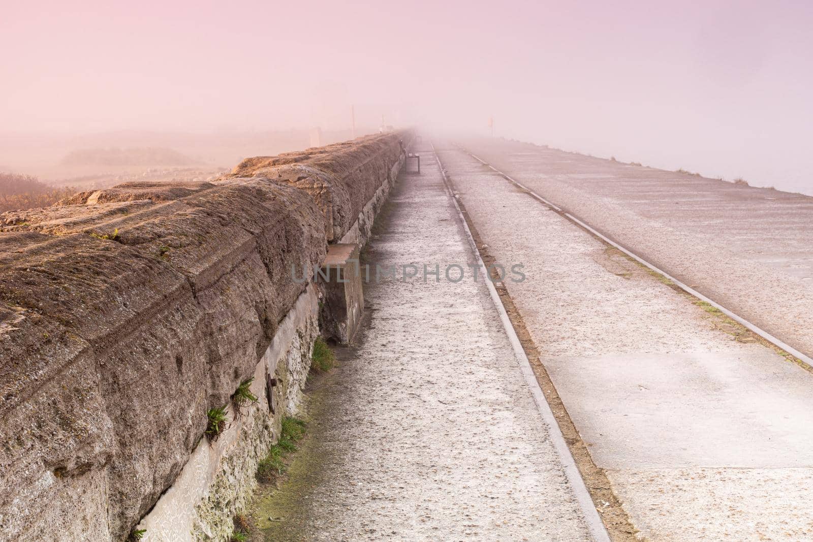 Sunrise light diffused by fog on the beach