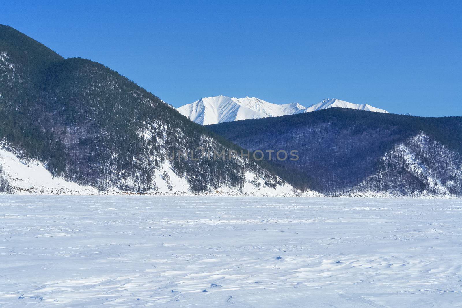 Baikal mountains in winter in snow. Forest in snow-covered mountains.
