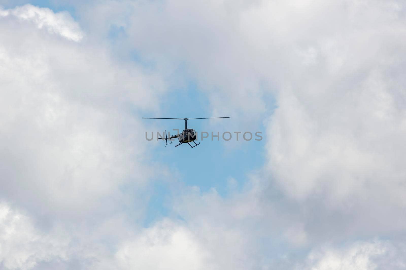 A helicopter flying with sightseeing tourists in a cloudy sky in regional Australia