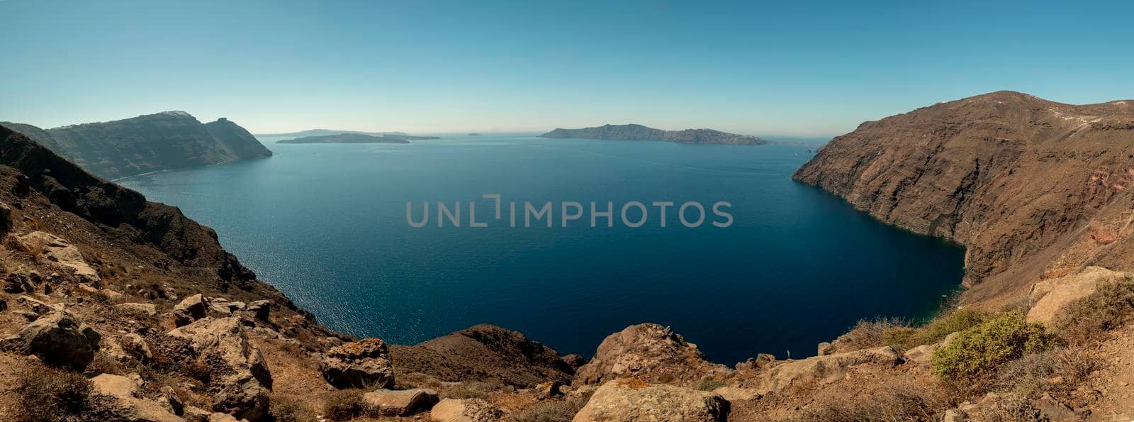 A large blue water bay with mountains on Santorini Island in Greece.