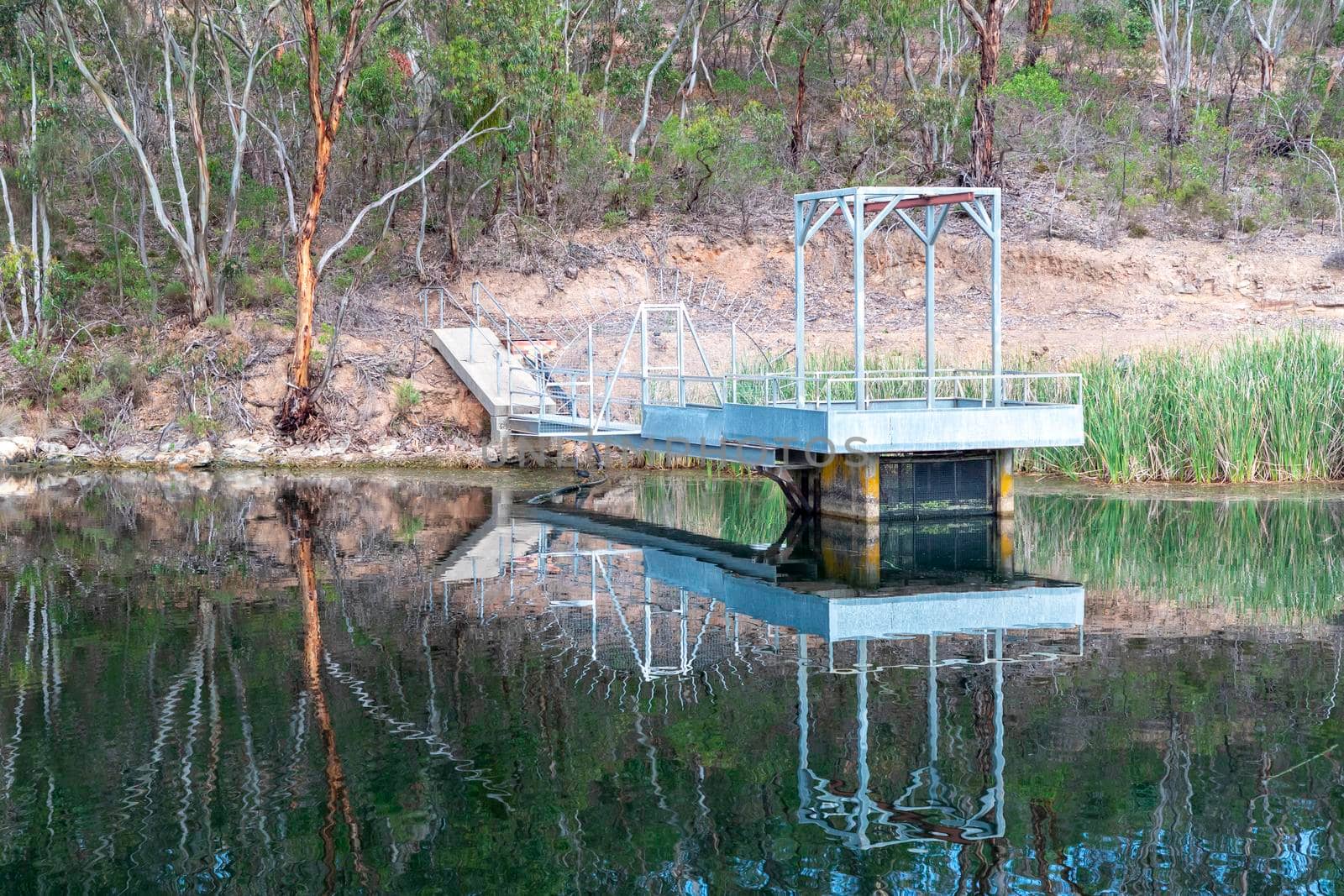 A pumping station platform in a water supply reservoir with a reflection in the water by WittkePhotos