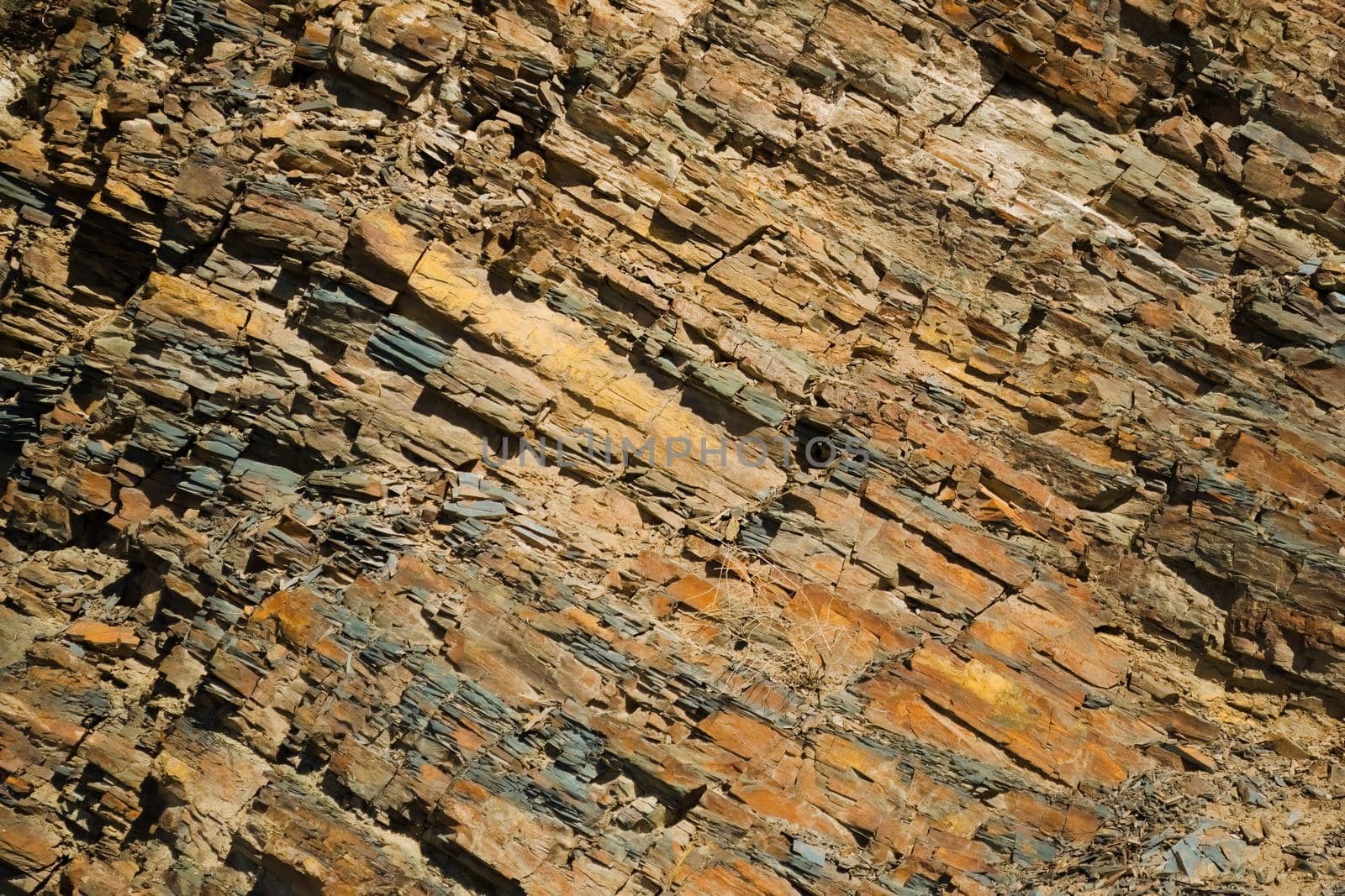 Reddish layered rock wall, with visible geological strata in the Andes mountains.