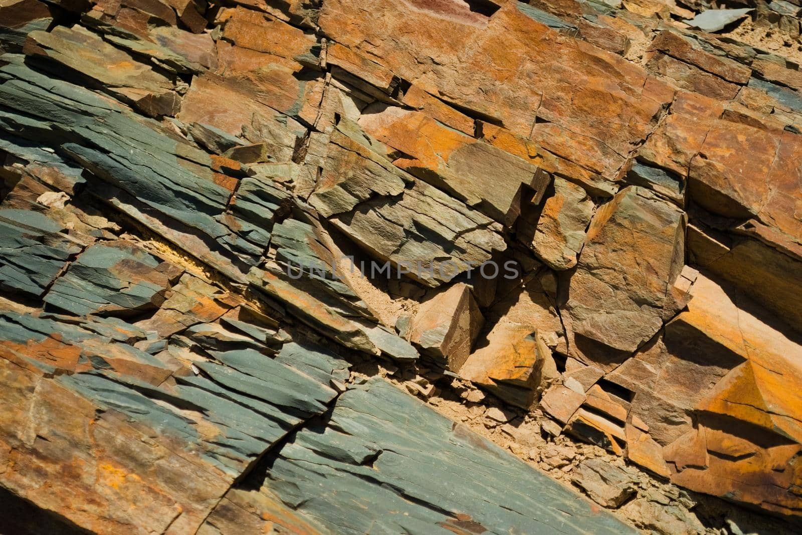 Reddish layered rock wall, with visible geological strata in the Andes mountains. by hernan_hyper