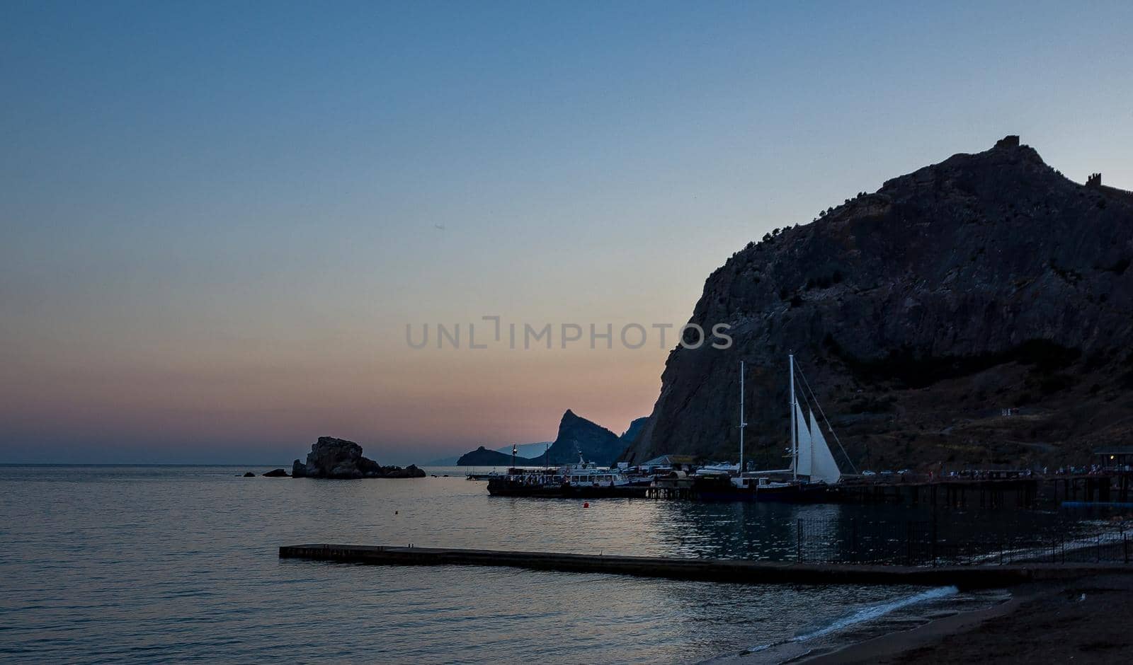 Sailing boats at the pier at the foot of the Fortress Mountain in Sudak.