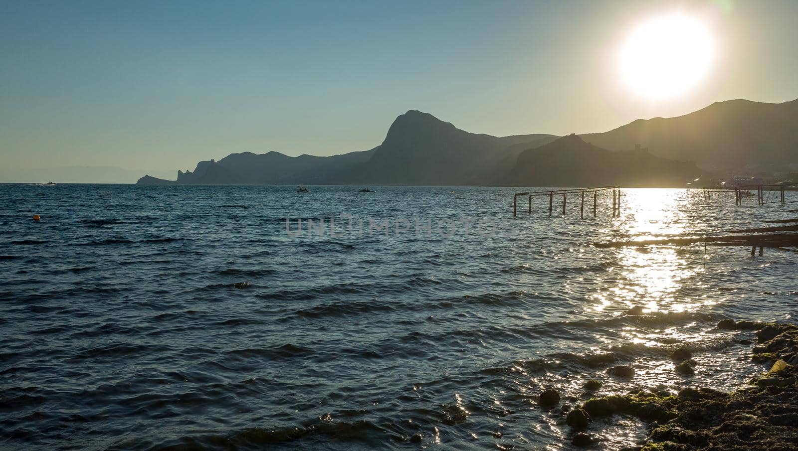 Rocks, slight sea waves at sunset on a warm summer evening.
