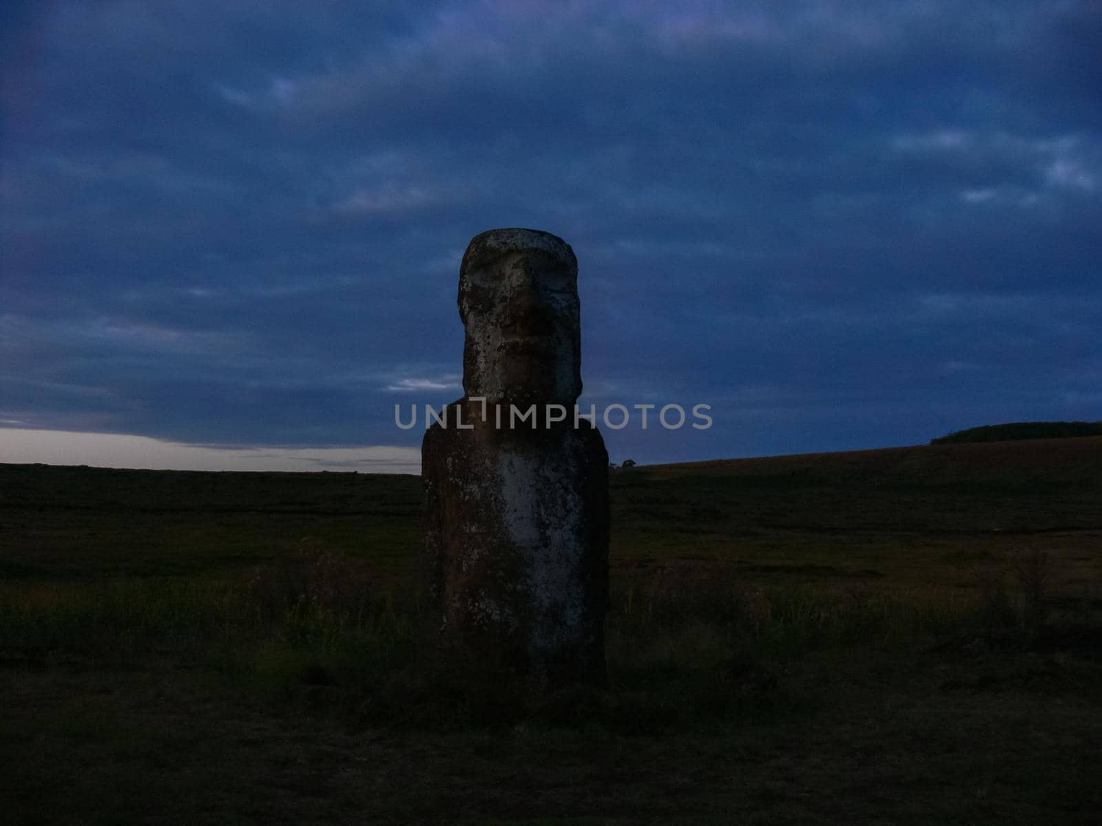 Statues of Easter Island in the background of the sunset. The melting of the Easter statue in the sunlight of the sunset.