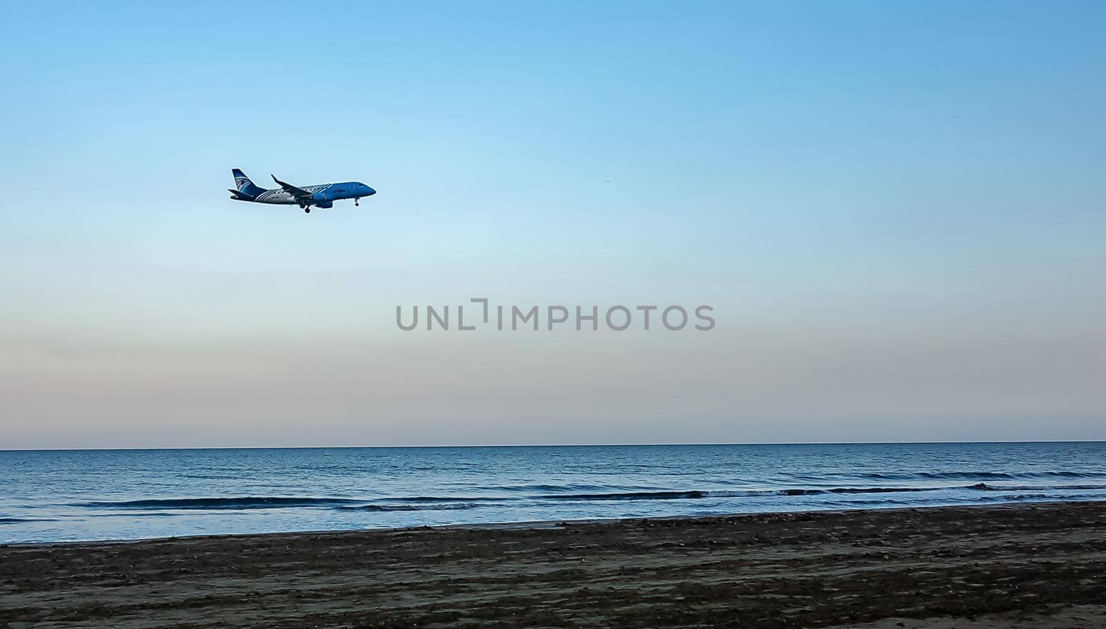 April 11, 2019 Larnaca, Cyprus. Plane of airline 
EgyptAir Express  comes in to land over the waters of the Mediterranean sea.