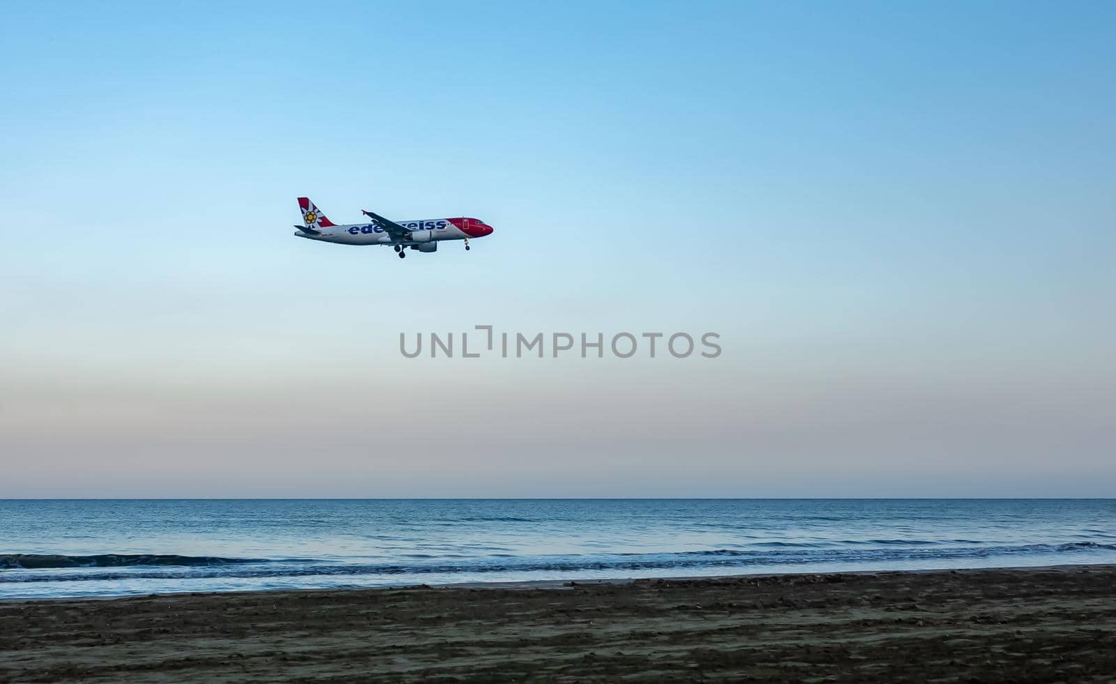 April 11, 2019 Larnaca, Cyprus. Plane of airline 
Edelweiss Air comes in to land over the waters of the Mediterranean sea.