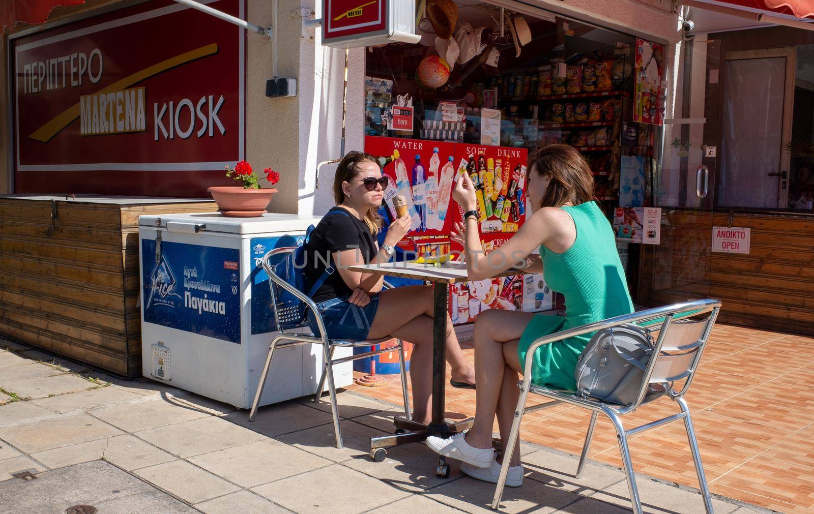 April 20, 2019, Paphos, Cyprus. Two young girls eat ice cream and chat in a summer cafe.