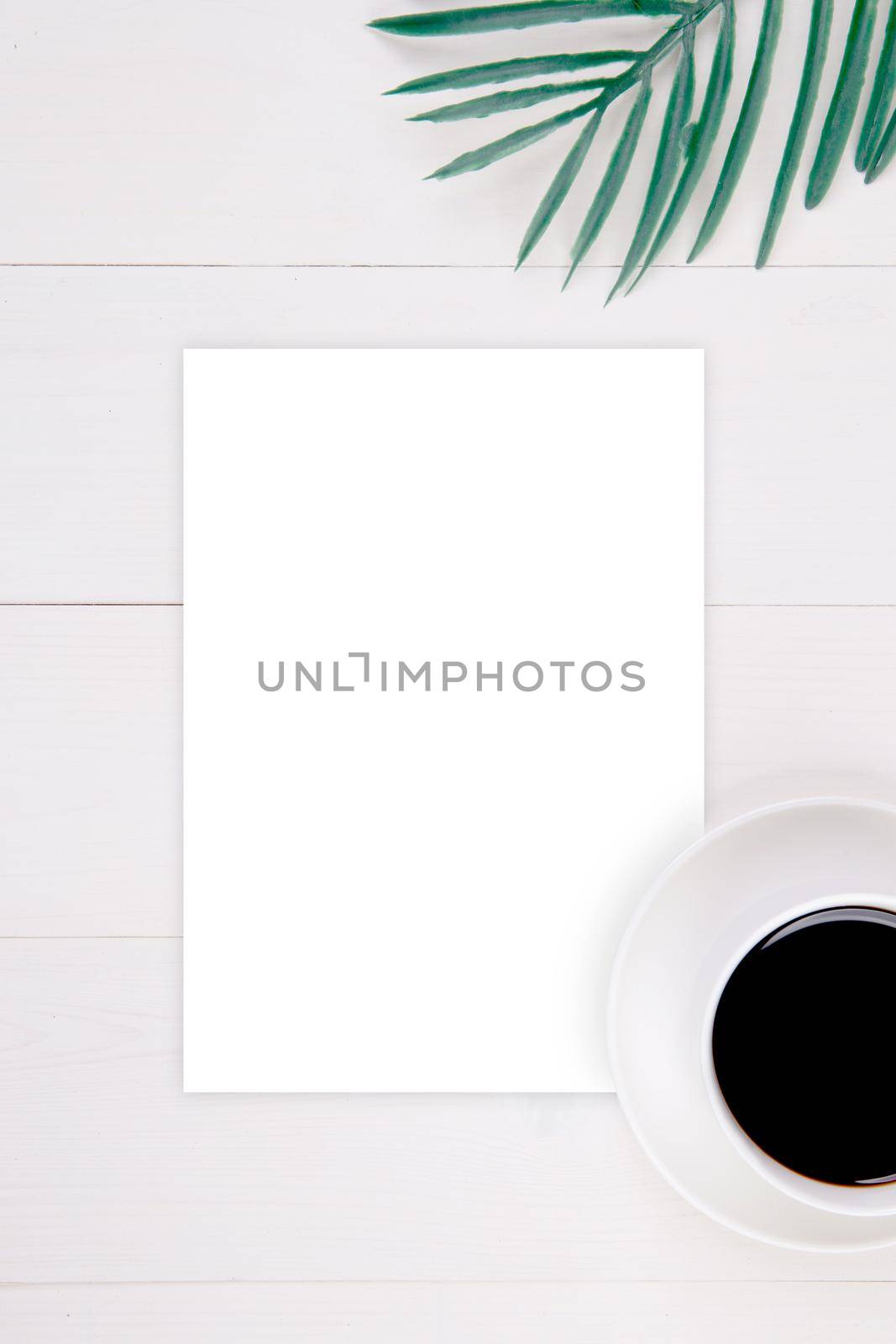 Blank paper sheet copy space with mockup and leaf and cup of coffee on wooden table, poster and invitation, postcard decoration your design or branding, nobody, flat lay, top view. by nnudoo