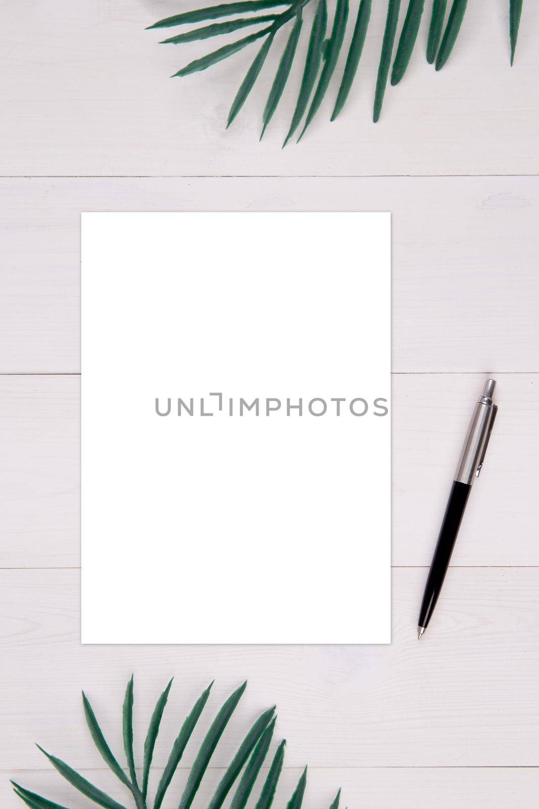 Blank paper sheet copy space with mockup and leaf on wooden table, poster and invitation, postcard decoration your design or branding, simplicity and minimal, nobody, flat lay, top view.