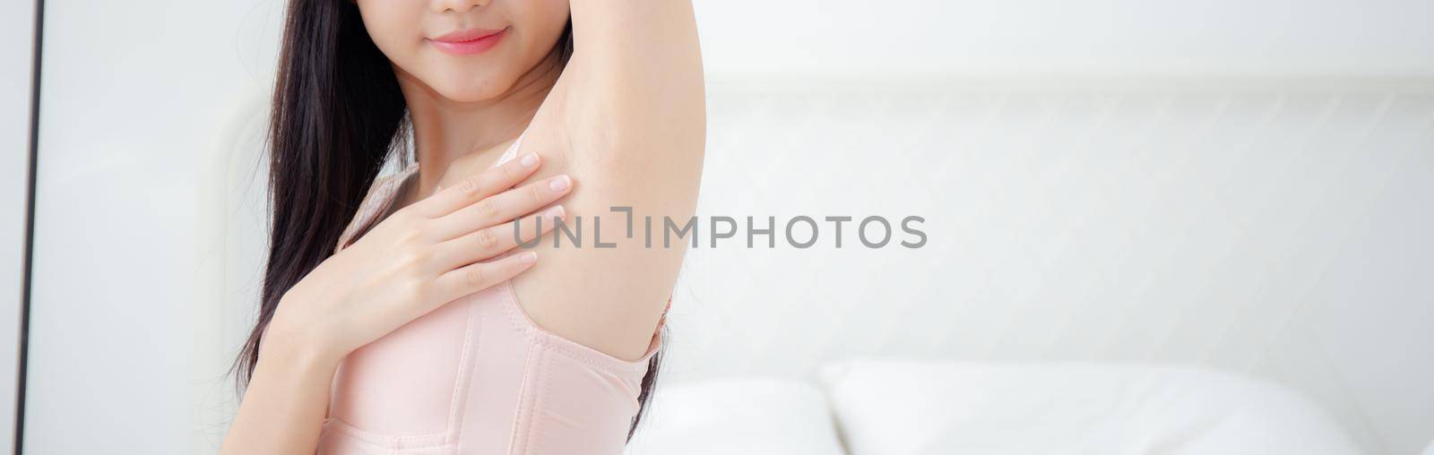 Beautiful young asian woman in underwear applying cream and lotion on armpit, beauty girl is slim happy touch skin armpit and hair removal, treatment and cosmetic and cleaning, baner website.