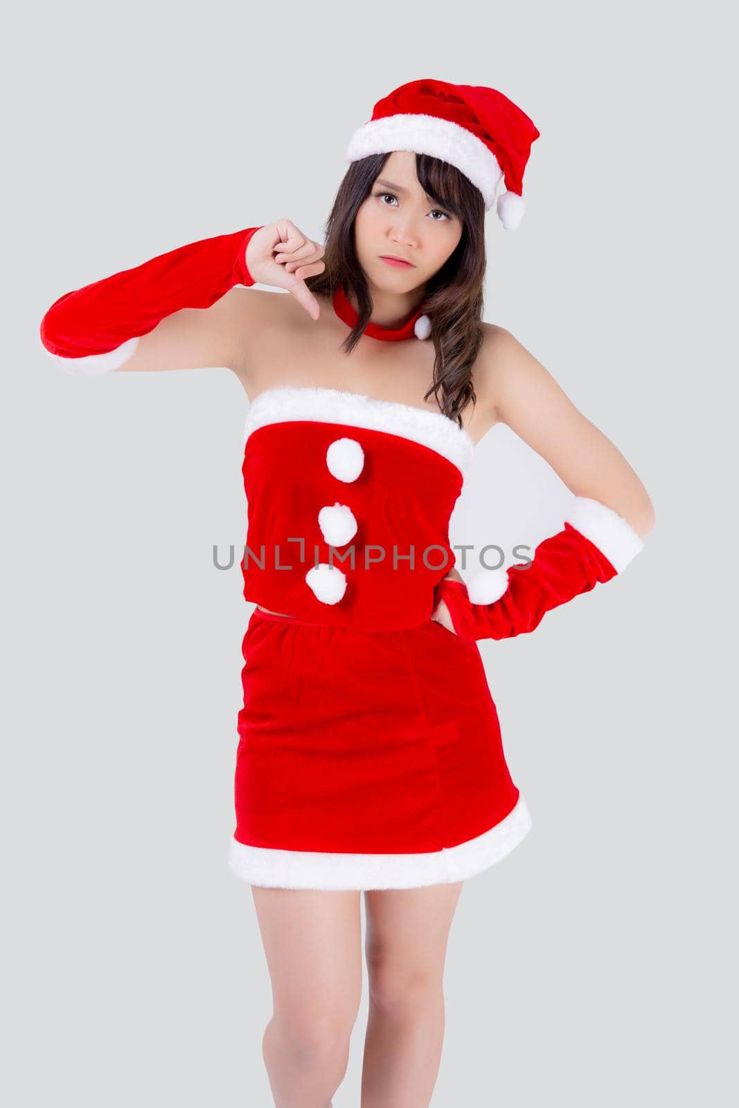 Beautiful portrait young asian woman Santa costume gesture thumbs down sign with unhappy negative in holiday xmas, beauty asia girl expression dislike and upset in Christmas isolated white background.