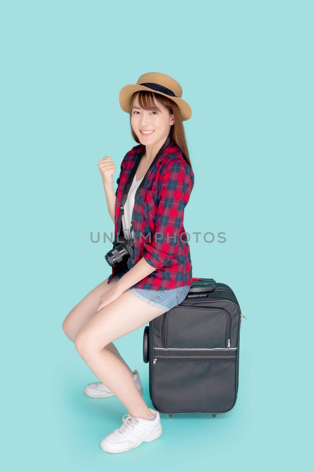 Beautiful portrait young asian woman sitting on luggage smile and travel summer trip for abroad in vacation, asia girl having camera gesture success and glad on suitcase for journey in holiday. by nnudoo