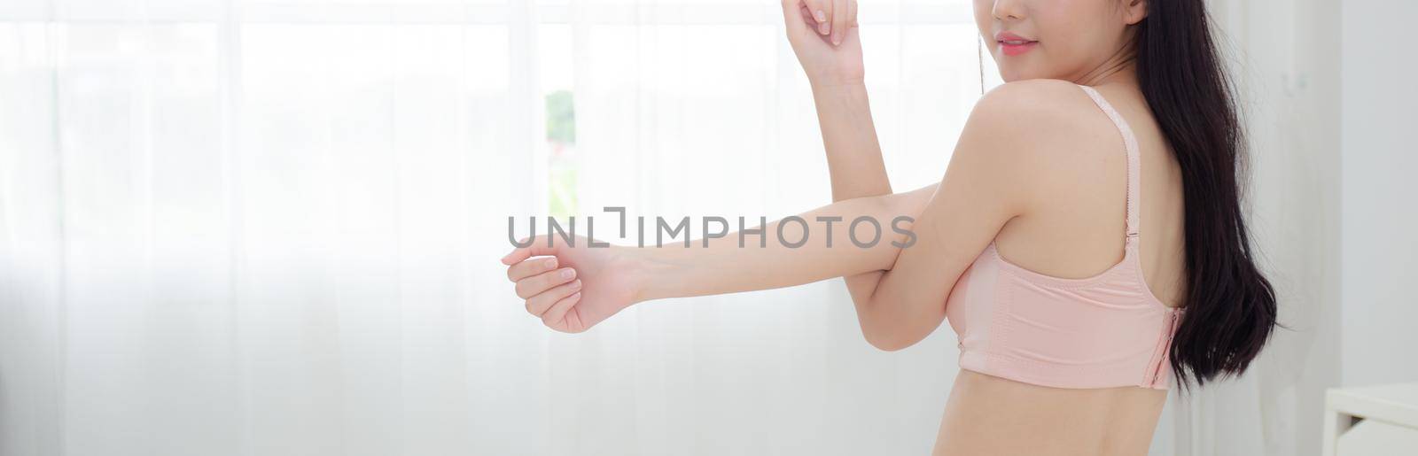 Beautiful young asian woman waking up in the morning and stretching arms on bed in the bedroom, sexy girl in underwear relax cozy and wake with happy at home, lifestyle concept, banner website. by nnudoo