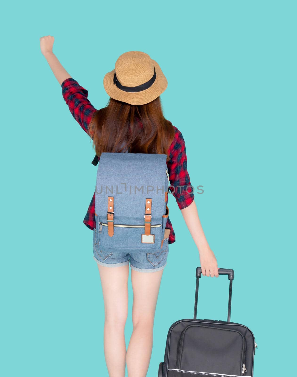 Back view beautiful young asian woman pulling suitcase isolated on blue background, asia girl having expression is cheerful holding luggage walking in vacation with excited, journey and travel concept.
