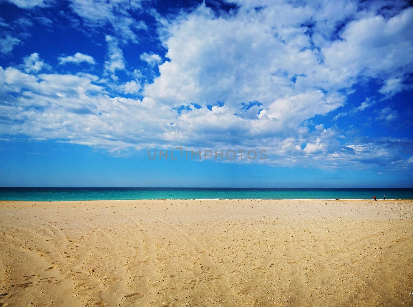 Amazing view of the emerald sea, yellow sand and blue sky with clouds, spring, Spain