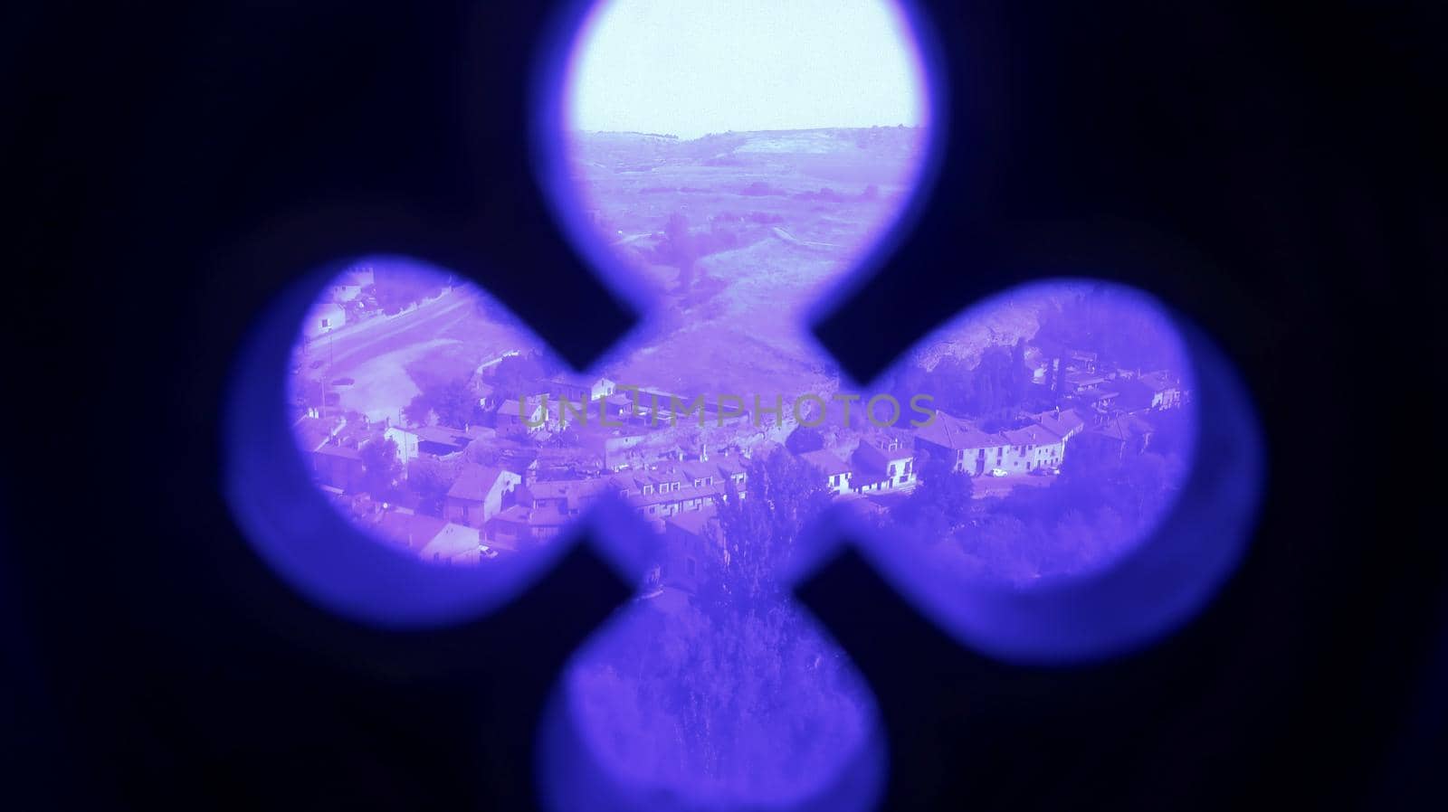 Cross ornament with purple glass and landspace of village