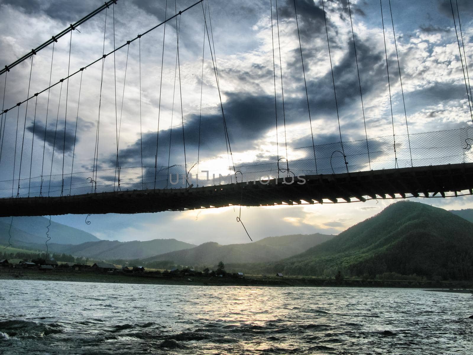 A hinged wooden bridge over the river somewhere on the altai.